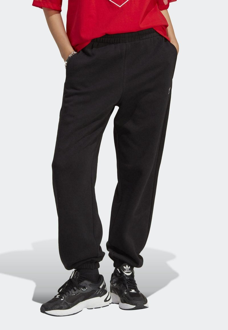 Black sweatpants with an elastic waistband and cuffs, made of soft fabric. Features side pockets and a small logo near the hem.