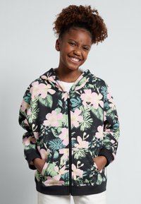 Sudadera con cremallera negra que presenta un colorido patrón floral con flores rosas y hojas verdes, bolsillos frontales y una capucha forrada.