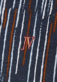Marinefarbener Stoff mit einem vertikalen Muster aus weißen und orangefarbenen Streifen; enthält pinkfarbene, gestickte Initialen "JV."