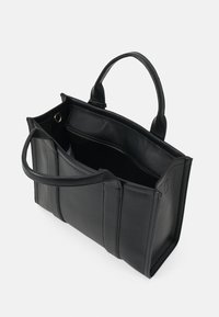 Black leather tote bag with two handles, featuring a smooth texture and open top. Interior shows a zippered compartment and unlined space.