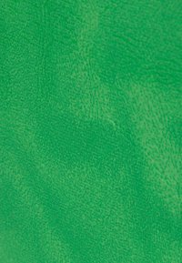 Tessuto testurizzato di un verde brillante, che mostra un sottile motivo con tonalità variabili e una superficie leggermente irregolare.