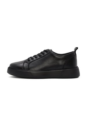 Zwarte leren low-top sneaker met vetersluiting en dikke rubberen zool, die de buitenzijde toont tegen een witte achtergrond.