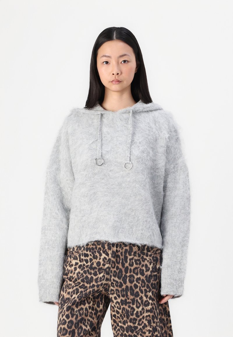 Grå, fluffig huva tröja med en beskuren design, med dragsko och silverfästen, matchad med leopardmönstrade byxor.