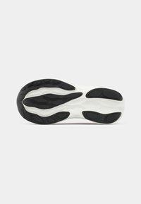 Semelle de chaussure blanche en caoutchouc texturé avec des accents noirs, des motifs ondulés et plusieurs pods de traction.