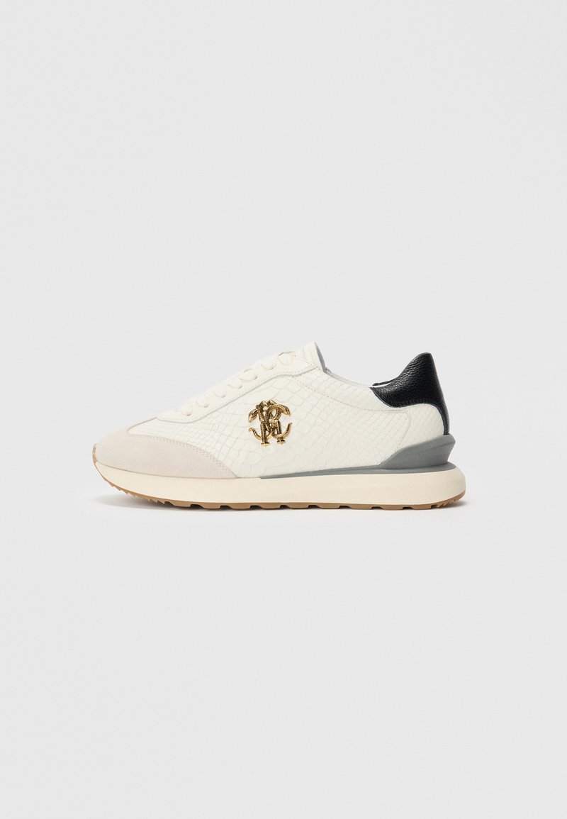 Valge madalate tossudega, millel on tekstuuriga külg, beež pealtäidis, must konts, hall keskosa joon ja kuldne omavahel seotud logo küljel.