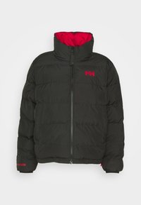 Zwarte pufferjack met een hoge kraag, ritssluiting aan de voorkant en rode binnenvoering. Kenmerken zijn horizontale stiksels en een rood logo op de borst.