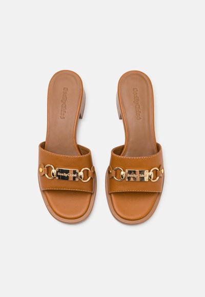 Braune Leder-Sandalen mit offener Zehenpartie, einem goldenen Kettenakzent und Logo-Platte, einem niedrigen Blockabsatz und einer glatten Textur.
