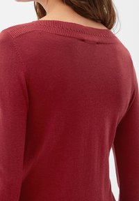 Rode trui met een ribbelneckline en een zachte, gladde textuur. Het ontwerp toont de achterkant, met lange mouwen en een aansluitende pasvorm.