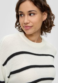 Leichtes Strickpullover in Weiß mit schwarzen horizontalen Streifen, mit Rundhalsausschnitt und strukturiertem Stoff für zusätzliche Details.