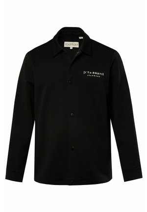 Chaqueta de camisa negra de manga larga hecha de un tejido suave, con un cierre de botones, cuello de punta y un gráfico de texto blanco en el pecho izquierdo.
