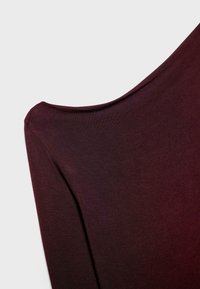 Bordo gornji dio s širokim izrezom i kratkim rukavima, napravljen od mekog, rastezljivog materijala. Odlikuje se glatkom teksturom i suptilnim sjajem.