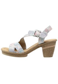 Korkokenkä, jossa on avonaiset varpaat, pastellivärinen kukkakuosi, hihna, säädettävä solki ja teksturoitu juuttikääreinen korko paremman pidon takaamiseksi.