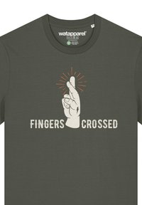 Olivegrünes Baumwoll-T-Shirt mit einem Grafikmotiv einer Hand mit einem erhobenen Zeigefinger. Darunter in Weiß der Text "FINGERS CROSSED" aufgedruckt.