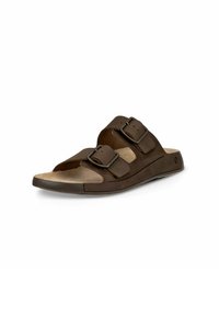 Brun sandal med två justerbara remmar och spännen. Mjuk fotbädd med en kurvad form, platt sula och en mönstrad yttersula för bra grepp.