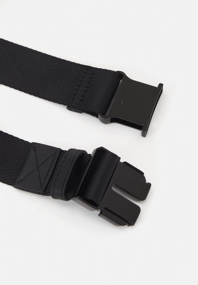 Cintura in nylon nero con doppie fibbie in metallo. Presenta una superficie testurizzata e forme rettangolari. Include un dettaglio in pelle vicino alla fibbia.
