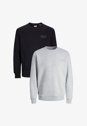 Two crewneck sweatshirts, one black and one light gray, made of soft fabric. Each features a small branded tag on the chest.