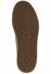 Gummisulor i brunt med cirkulärt greppmönster. Har präglad logotyp och en slät kant. Bred form med en distinkt mönstring.