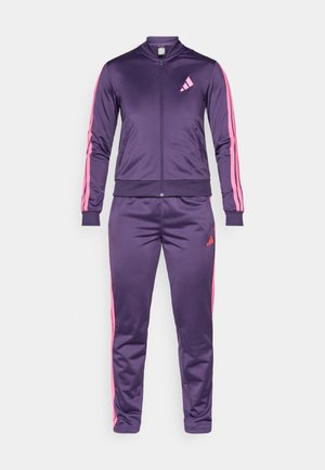 Chándal morado hecho de una tela suave, que incluye una chaqueta con cremallera y cuello alto, adornada con franjas rosas a los lados, combinada con pantalones a juego.