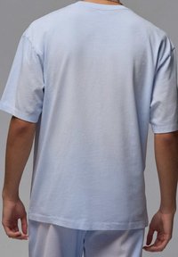 Světle modré bavlněné tričko s krátkým rukávem, kulatým výstřihem a hladkou texturou. Jednoduchý design, žádné viditelné vzory ani ozdoby.