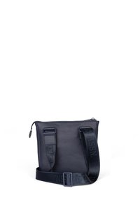 Námořnická modrá kožená crossbody taška s texturovaným povrchem, zipovým uzávěrem a nastavitelným popruhem se soutiskem loga. Kompaktní obdélníkový tvar.