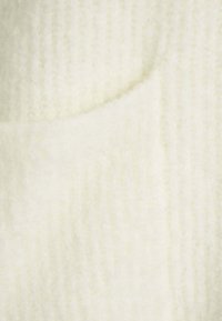 Tessuto color crema caratterizzato da una superficie morbida e testurizzata con righe verticali, completato da una sezione curva e liscia.