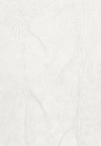 Primo piano di un tessuto lavorato a maglia bianco con un motivo centrale a treccia e una texture morbida e pelosa.