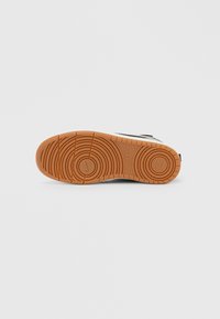 Guminė batų padas oranžinės spalvos su apvaliais protektoriaus raštais. Viršutinėje krašto dalyje juodas dizainas. Butas ir apvalus formos siluetas stabilumui užtikrinti.