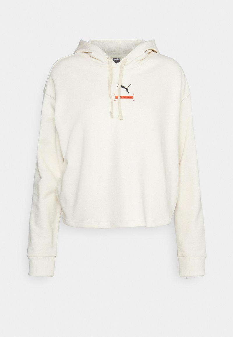 Hoodie cropped color crema, realizzato in tessuto morbido. Presenta un cappuccio con coulisse e un piccolo logo Puma nero con dettagli rossi al centro.