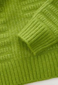 Pulover tricotat verde, cu manșete cu dantelă și țesătură texturată. Material moale, cu nuanțe variate de verde și modele subtile.