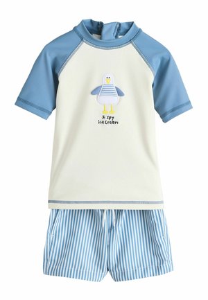 Set di costumi da bagno per bambini con maniche corte azzurro chiaro, corpo color crema con un gabbiano e la scritta "I spy ice cream", e pantaloncini a righe blu e bianche.