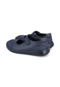 Zapatos estilo Mary Jane de color azul marino con una correa de Velcro, hechos de cuero con una textura suave y una suela acolchada para mayor comodidad.