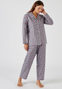 Grijze pyjama set met stippen in roze, wit en blauw. Langere mouwen met een knoopsluiting bovenkant en broek met een ontspannen pasvorm en geborduurde accenten.