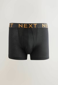 Boxer cortos negros con cintura elástica que presenta la palabra "NEXT" en letras naranjas. Confeccionados con una tela suave y un diseño ajustado.