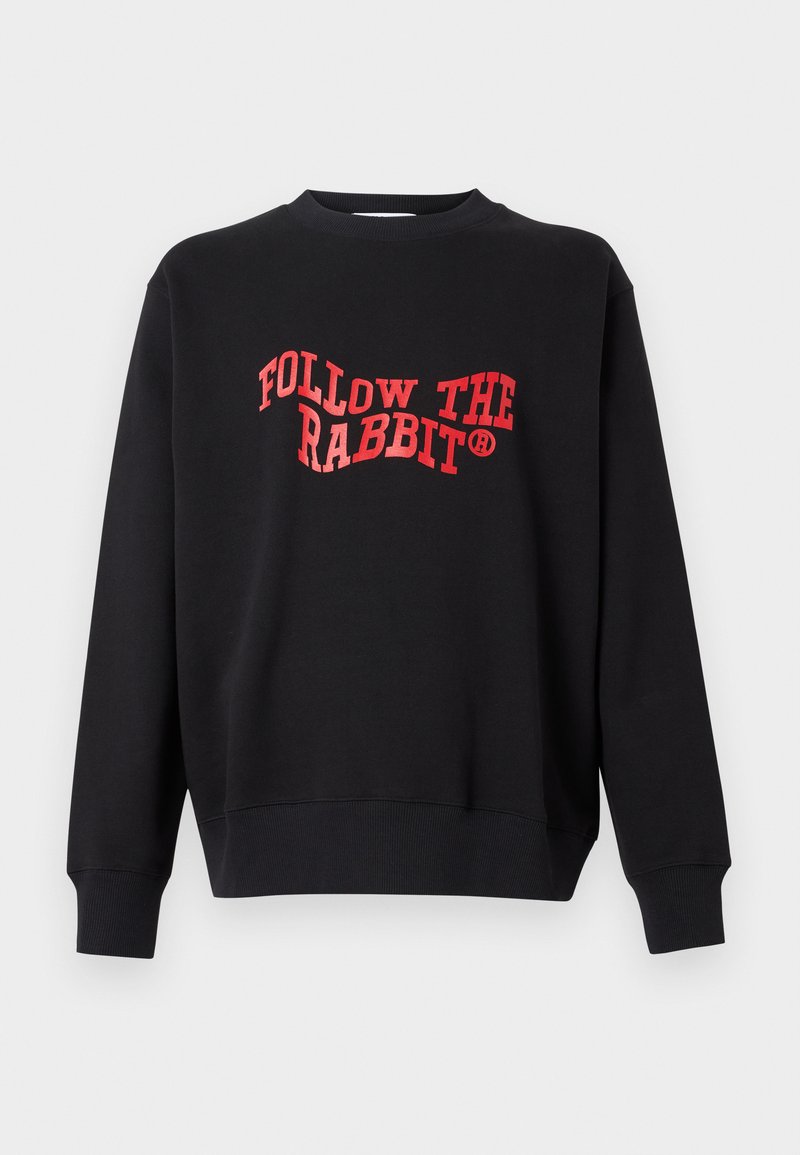 Zwarte sweatshirt met ribgebreide mouwen en onderkant, voorzien van de tekst "VOLG DE KONIJN" in vetgedrukte rode gebogen letters op de voorkant.