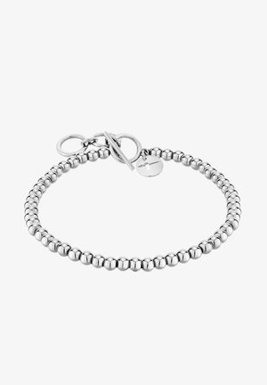 Sølvperlesnor med en glat tekstur, runde polerede perler og en toggle-lås med en cirkulær charmsdetalje.