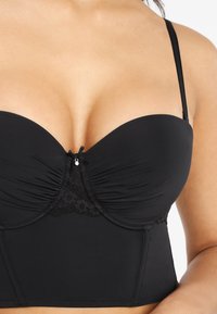Black underwire bra featuring padded cups, ruched detailing, lace accents, and adjustable straps. Smooth material with a structured shape.