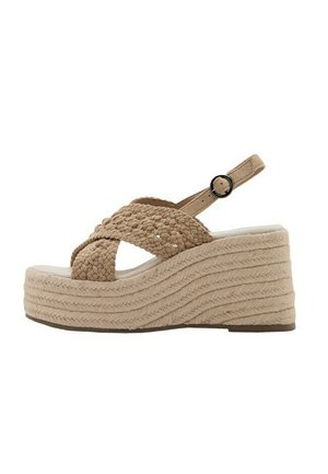 Sandalia cuña beige con tiras trenzadas cruzadas, hebilla en el tobillo y suela plataforma texturizada.