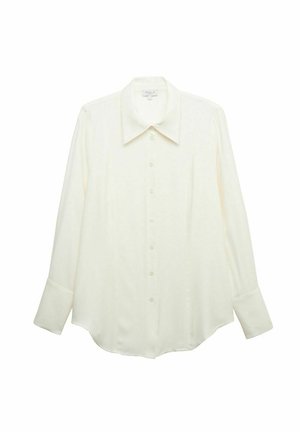 Valkoinen nappipaita, joka on valmistettu sileästä kankaasta. Paidassa on teräväkauluksellinen malli, pitkät hihat ja hieman pyöristetty helma. Yksinkertainen muotoilu ilman kuvioita.