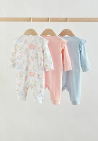 Trois grenouillères pour bébé à manches longues avec des épaules à volants, suspendues sur des cintres en bois ; les couleurs et motifs comprennent floral, rose avec des points et bleu avec des fleurs.