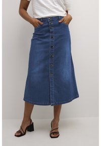 Jeans A-lijn rok met knopen aan de voorkant, vijf zakken en een split. Heeft een rijke blauwe kleur en een gladde, stevige textuur.