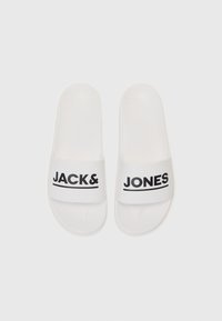 Des sandales blanches à semelle plate en plastique lisse avec une large lanière portant le texte "JACK&" et "JONES" en lettres noires gras.