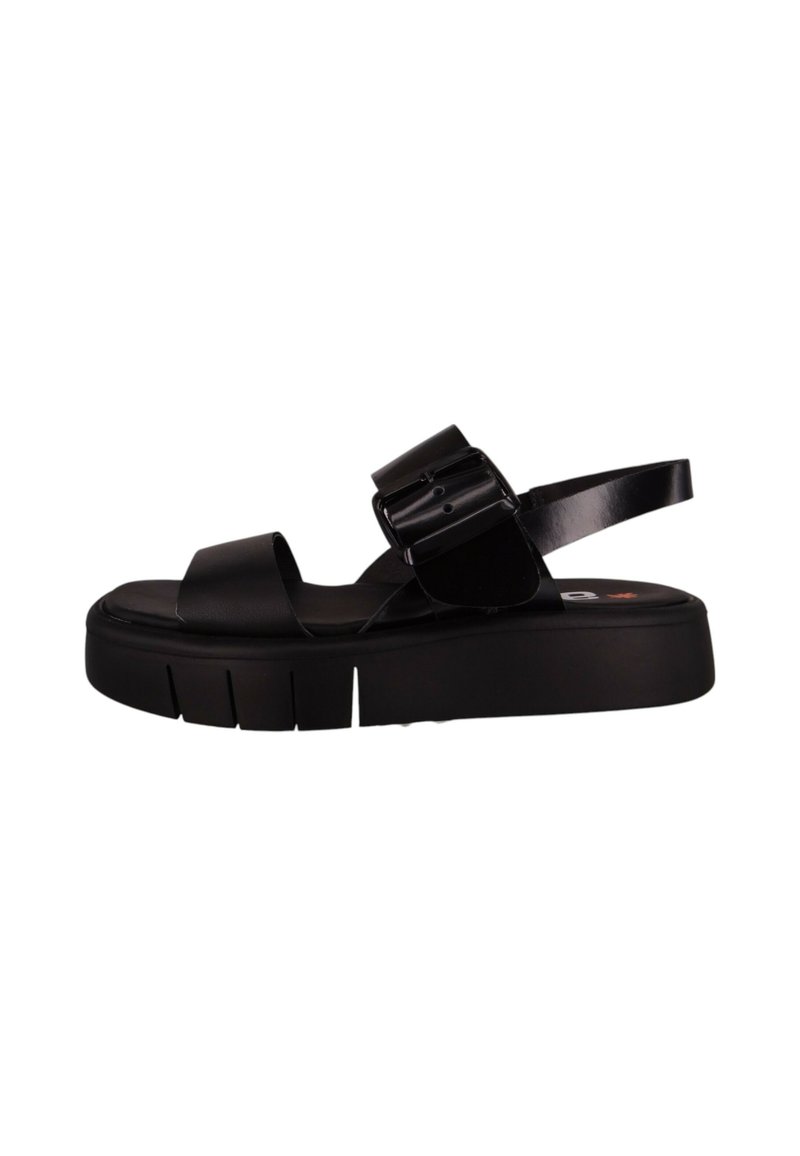 Sandalias de plataforma negras con correas anchas y planas, hebillas ajustables y una suela texturizada con ranuras horizontales para mayor agarre.