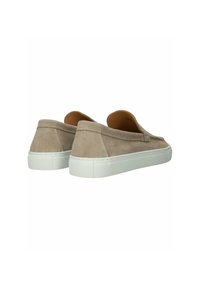 Beige suède instapsneakers met witte rubberen zolen, zichtbare stiksels en een laag uitgesneden ontwerp, gezien vanaf de achterkant en zijkant.