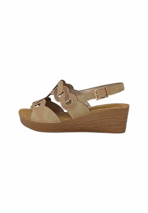 Sandalo beige con zeppa con motivo floreale traforato, cinturino regolabile alla caviglia con fibbia e suola platform texturizzata.