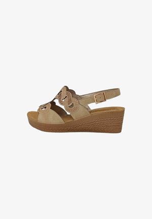 Sandalo beige con zeppa con motivo floreale traforato, cinturino regolabile alla caviglia con fibbia e suola platform texturizzata.