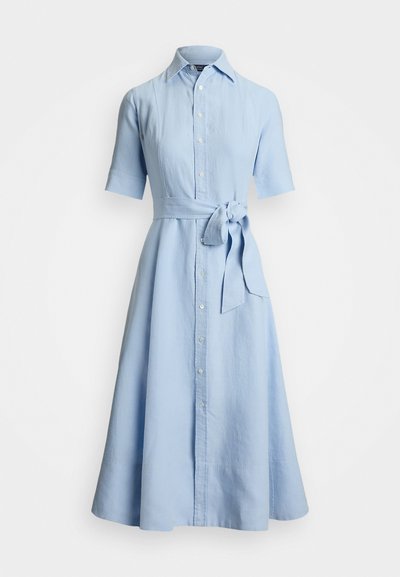 Gai zila lina kleita ar apkakles dekoltē, īsām piedurknēm, pogu aizdari priekšā un noņemamu saiti viduklī. Izplesta svārku daļa.