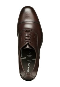 Scarpa da uomo in pelle marrone con punta arrotondata, cuciture sottili e allacciatura frontale. Presenta una suola nera testurizzata e una soletta traspirante.