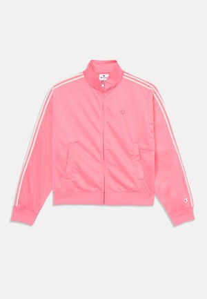 Lyserød zip-up jakke lavet af glat, let materiale. Har hvide sidelange striber, ribbede manchetter og lommer foran. Champion-logoet er vist.