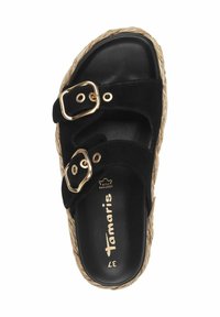 Sandalo slide in suede nero con due fibbie dorate, suola in juta intrecciata e una soletta nera liscia. Il nome del marchio "Tamaris" è impresso in oro.