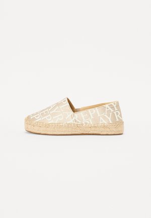 Espadrille shoe in beige canvas with large white lettering. Features a jute rope sole and rounded toe. Minimalist design with no additional accents.